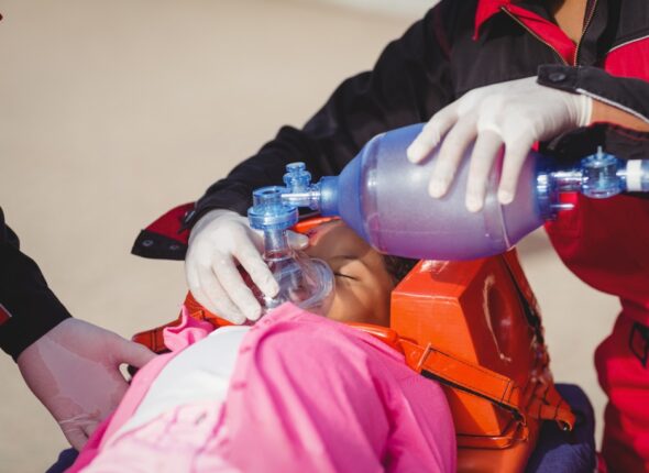 Paramedic giving oxygen to injured girl